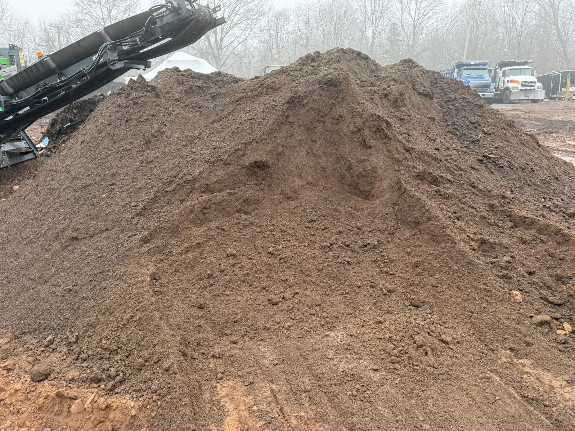 Pile of freshly screened topsoil at a Central Connecticut landscaping supply yard, showcasing rich, fine-textured soil ideal for lawns, gardens, and grading projects.