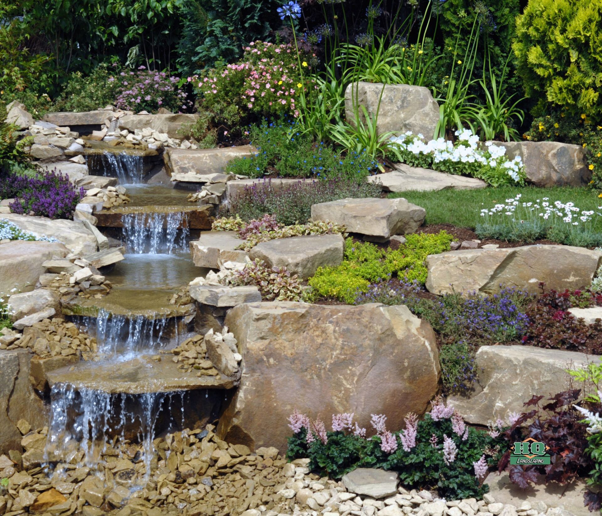 Custom backyard pond and water feature installation with natural stone by HQ Landscaping in Bristol CT