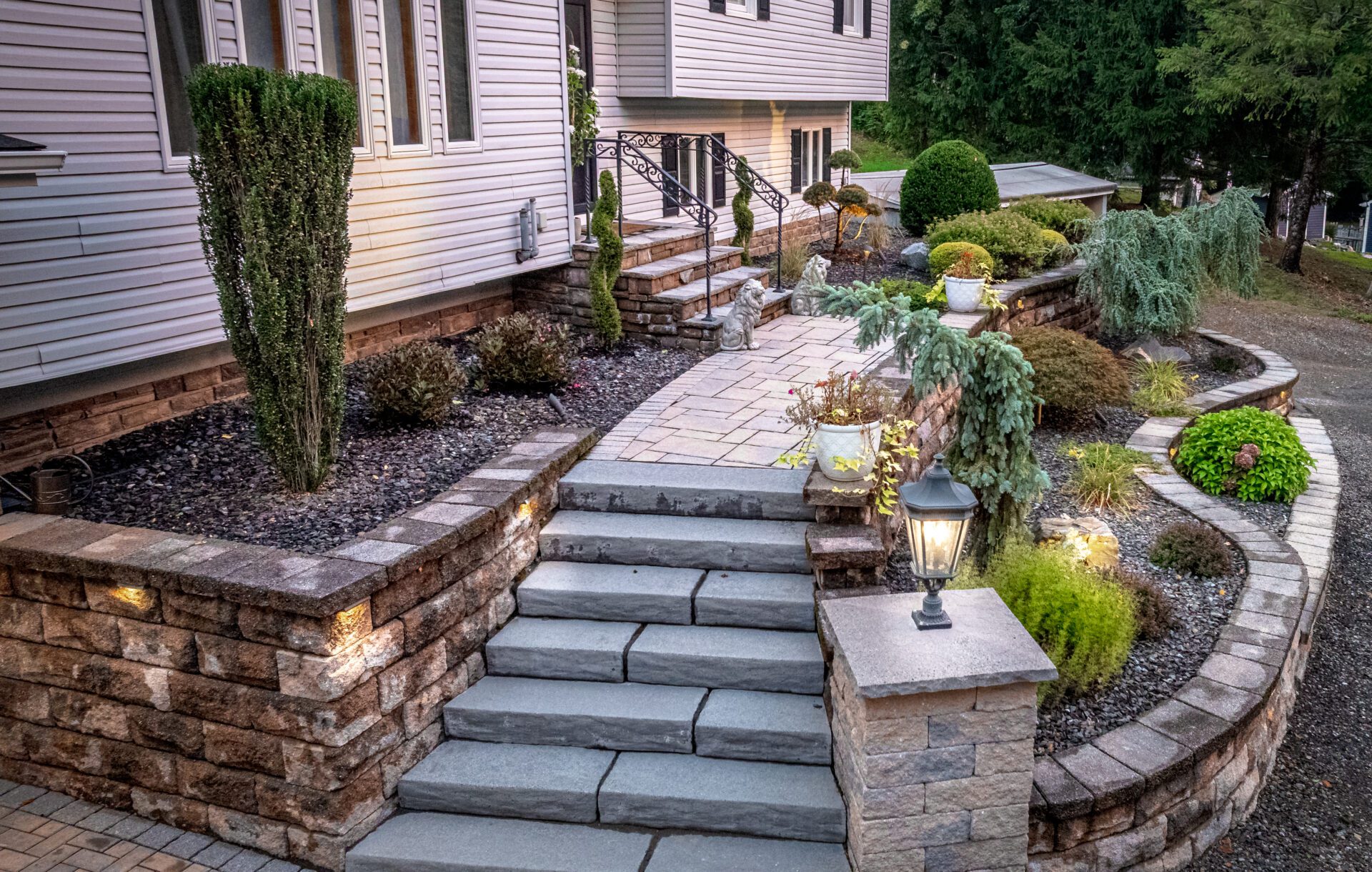 Front yard fall landscaping services with stone steps, shrubs, and lighting in Southington CT